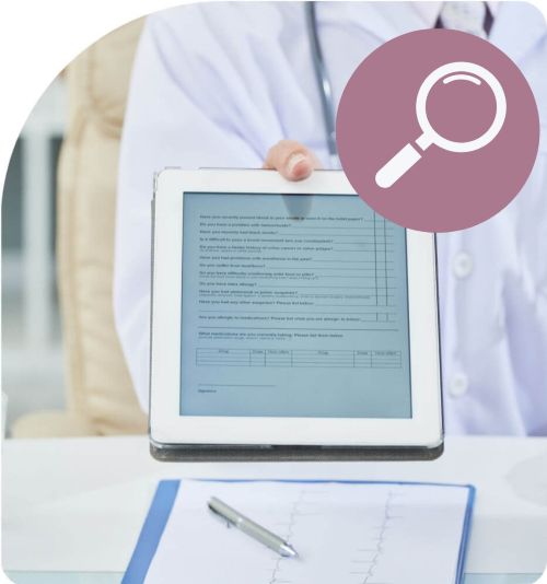 Ein iPad, welches mit einem Patientenfragebogen von einem Arzt entgegengehalten wird mit einem Lupenicon in der rechten Ecke.